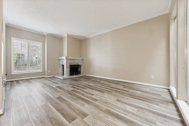 a view of empty room with wooden floor and fireplace