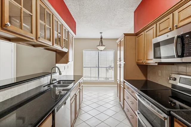 a kitchen with stainless steel appliances granite countertop a sink stove and cabinets