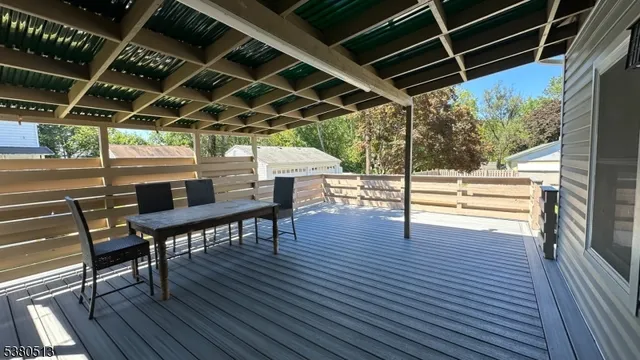 a view of a patio with table and chairs with wooden floor and fence