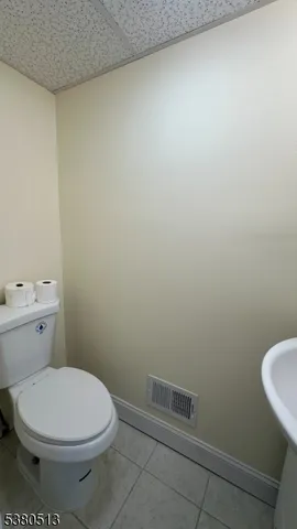 a white toilet sitting next to a white sink and vanity