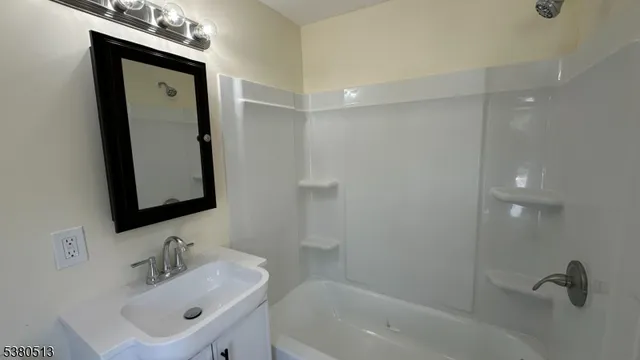 a bathroom with a sink a mirror and a shower