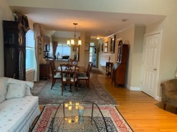 a living room with furniture a dining table and chairs with wooden floor