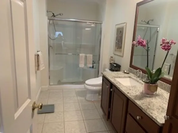 a bathroom with a granite countertop sink a toilet and shower