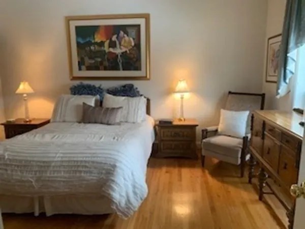 a bedroom with a bed and a painting on the wall