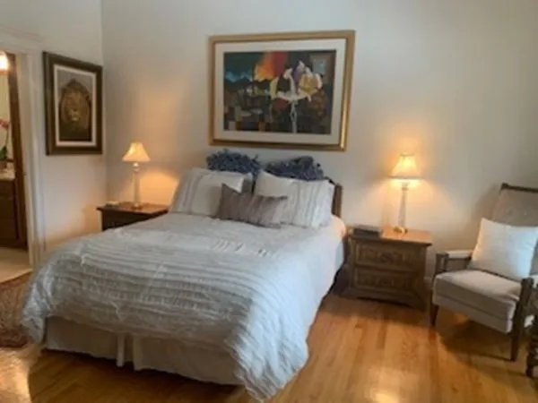 a bedroom with a bed and a lamp with wooden floor