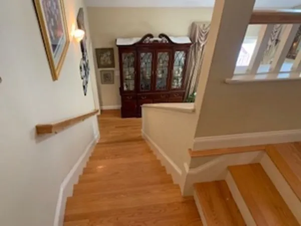 a view of a hallway with wooden floor and staircase