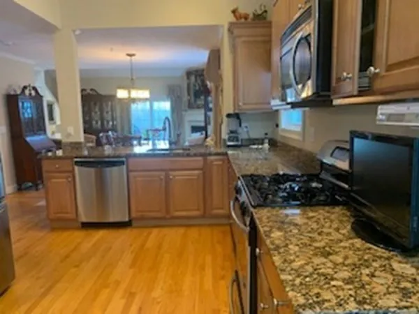 a kitchen with stainless steel appliances granite countertop a stove a sink and a microwave