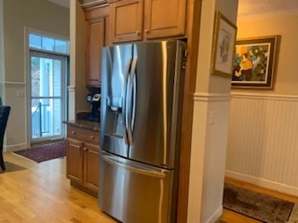a view of a refrigerator in kitchen and wooden floor