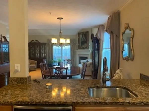 a kitchen with kitchen island a sink granite counter top a dining table and chairs