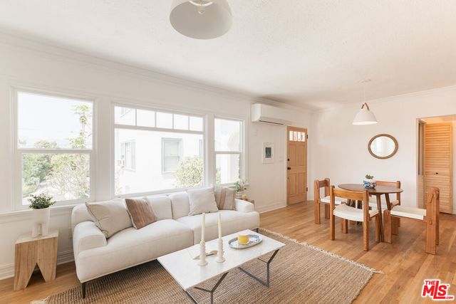 a living room with furniture wooden floor and a large window