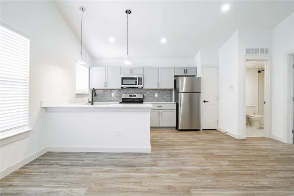 a kitchen with kitchen island a white counter top space cabinets and stainless steel appliances