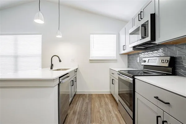 a kitchen with stainless steel appliances granite countertop a sink stove and microwave