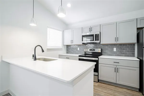 a kitchen with white cabinets and stainless steel appliances