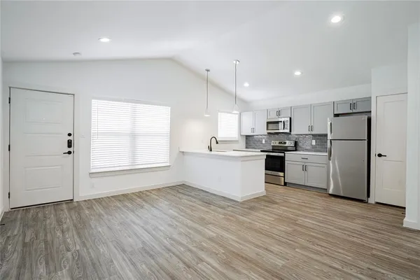 a kitchen with a refrigerator and white cabinets