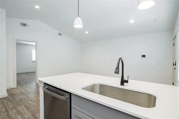 a kitchen with a sink and wooden floor
