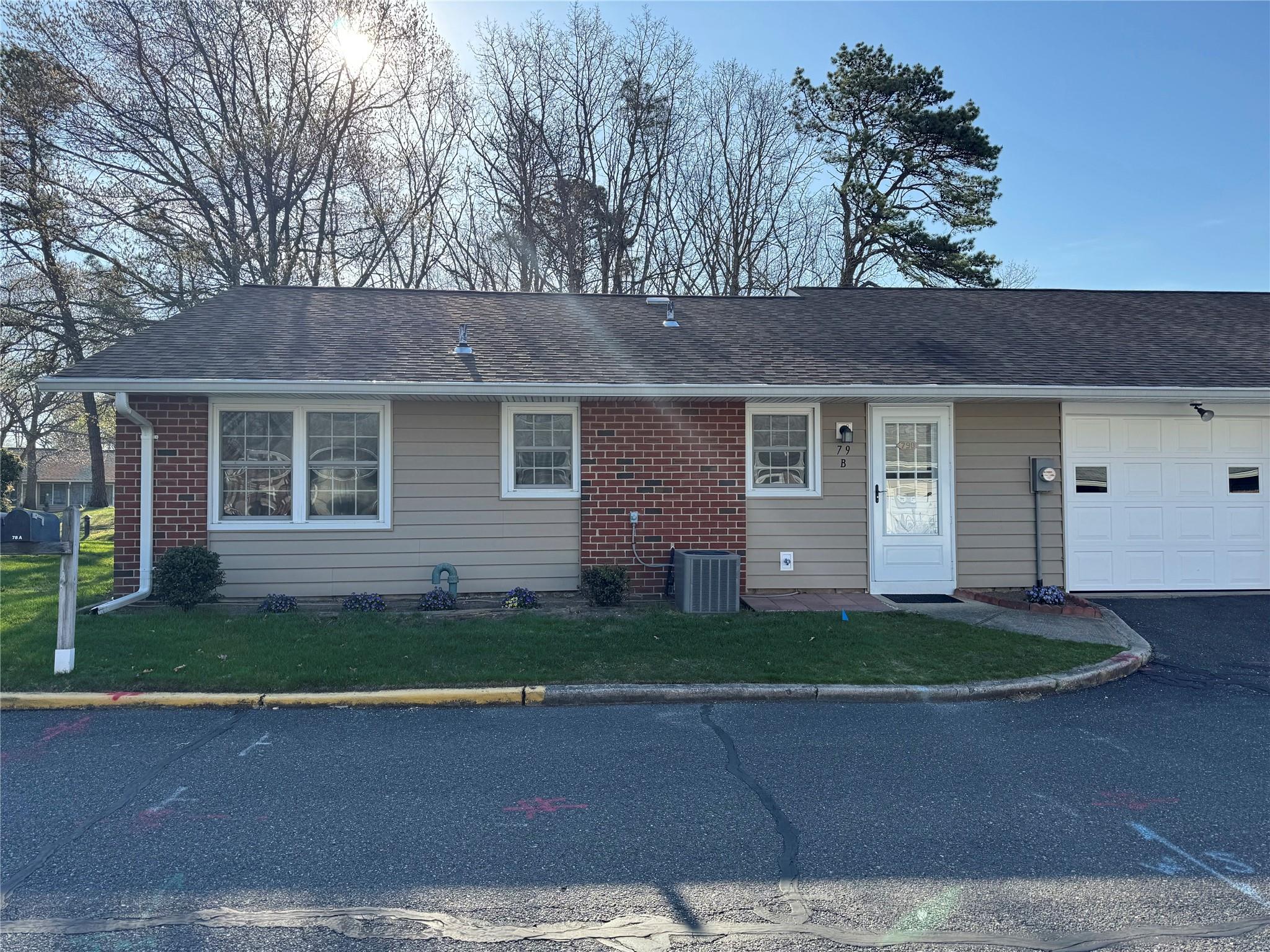 79 Enfield Court, Unit B Ridge, NY 11961 - Photo 1 of 1 View of front of home with a front lawn, roof with shingles, and a garage