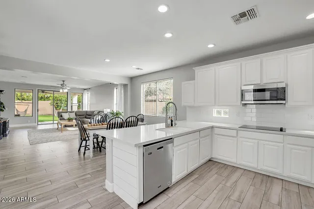 a kitchen with sink a microwave and cabinets