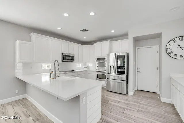 a kitchen with refrigerator cabinets and wooden floor