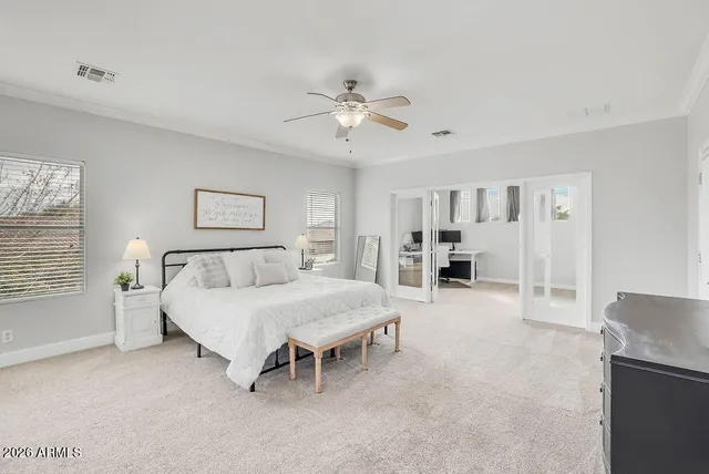 a spacious bedroom with a bed and a chandelier