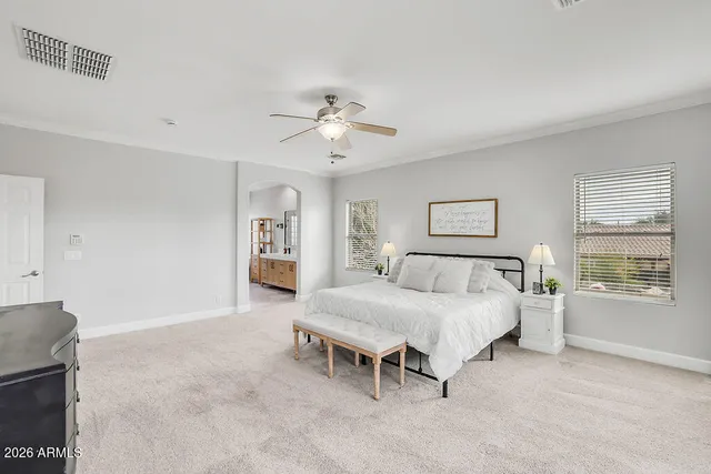 a bedroom with a bed chandelier and a window