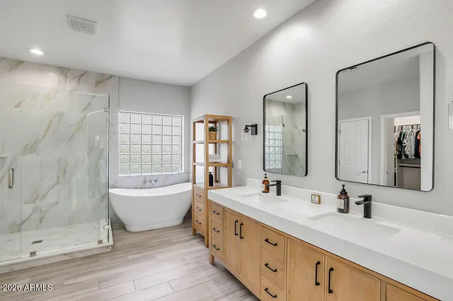 a bathroom with a double vanity sink mirror double and bathtub
