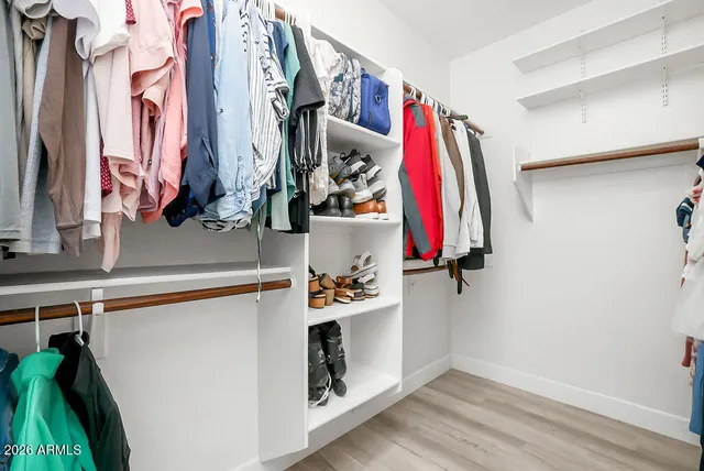 a view of walk in closet with clothes and shoes