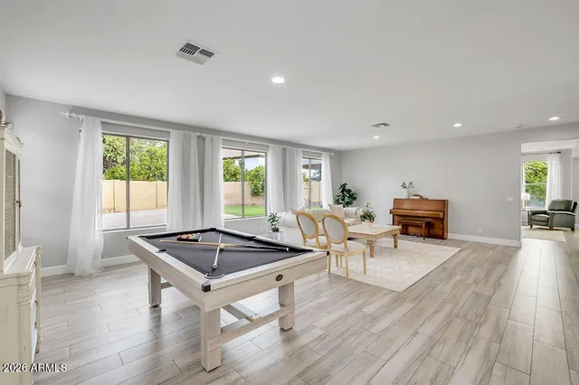 a living room with furniture a window and wooden floor