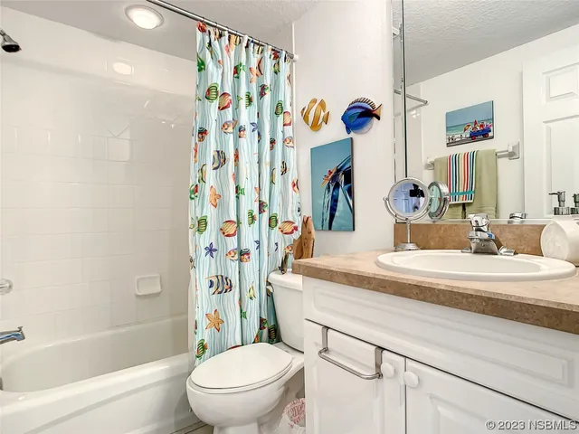 a bathroom with a bathtub sink vanity mirror and toilet