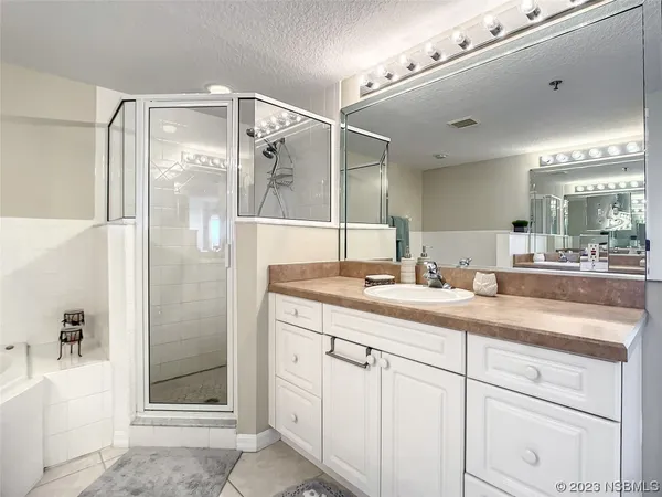 a bathroom with a shower sink and mirror