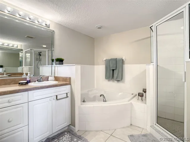 a bathroom with a bathtub a double vanity sink and mirror