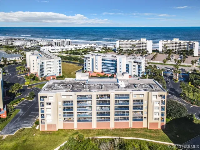 a front view of a building with a garden