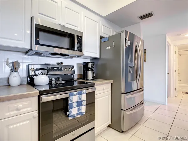 a kitchen with stainless steel appliances granite countertop a refrigerator stove and microwave