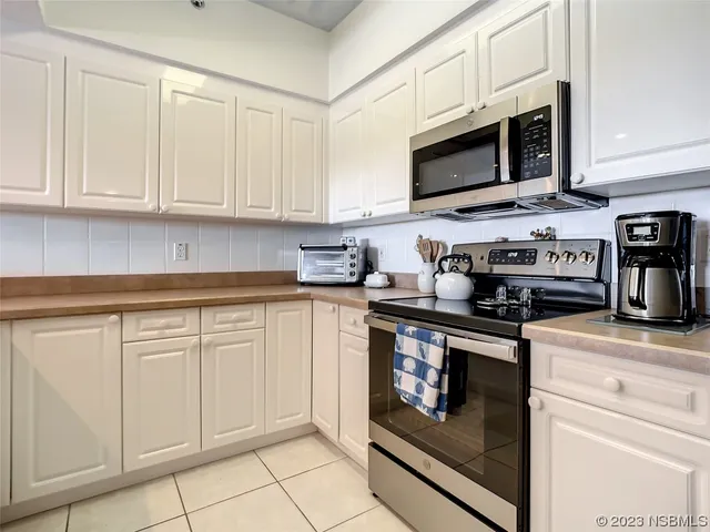 a kitchen with stainless steel appliances granite countertop grey cabinets a stove a sink and dishwasher
