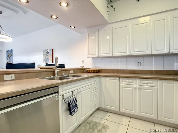 a kitchen with white cabinets sink and stove