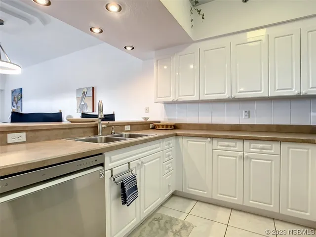 a kitchen with white cabinets sink and stove