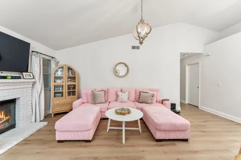 a living room with furniture a fireplace and flat screen tv