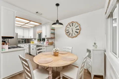 a kitchen with a dining table chairs and a chandelier