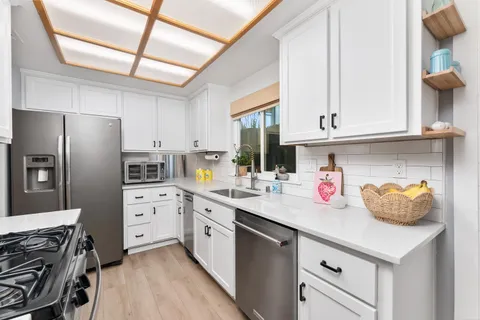 a kitchen with stainless steel appliances a sink stove and refrigerator