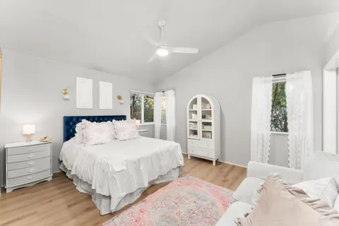 a bedroom with a large bed and a chandelier