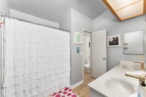 a bathroom with a sink a toilet and shower