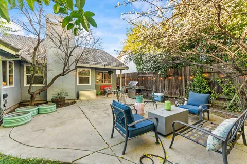 a view of backyard with table and chairs and a barbeque