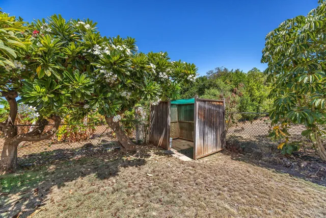 a backyard of a house with table and chairs under an umbrella