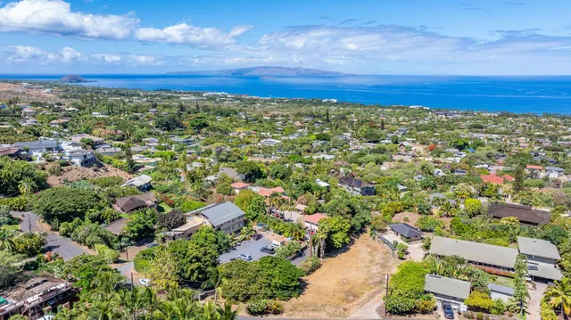 an aerial view of residential houses with outdoor space and trees