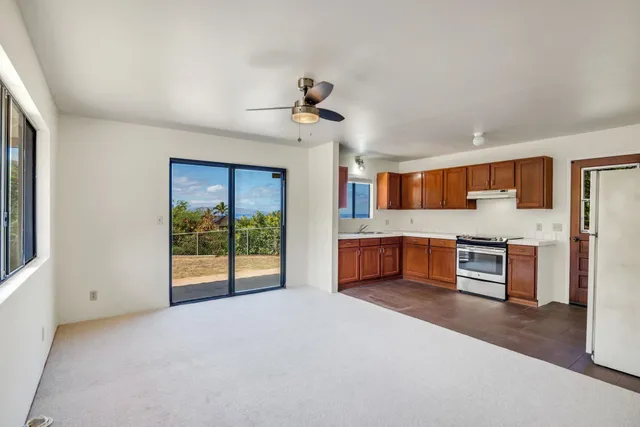a view of kitchen with granite countertop cabinets and refrigerator