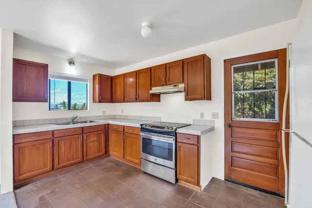 a kitchen with stainless steel appliances granite countertop a stove sink and cabinets