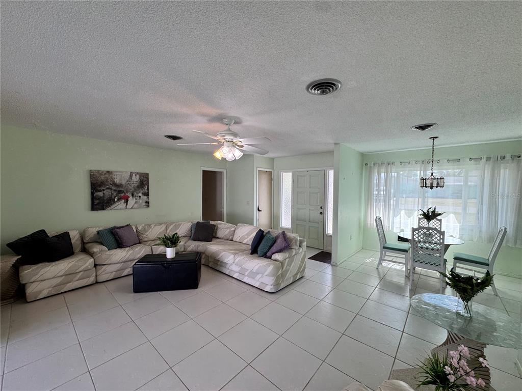 1048 Porpoise Road Venice, FL 34293 - Photo 11 of 26 a living room with furniture and a chandelier