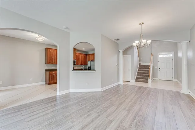 a view of an empty room with window and wooden floor