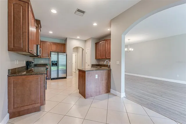 a kitchen with stainless steel appliances granite countertop a sink and cabinets with wooden floor