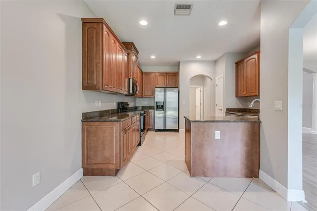 a kitchen with stainless steel appliances granite countertop a stove sink and cabinets