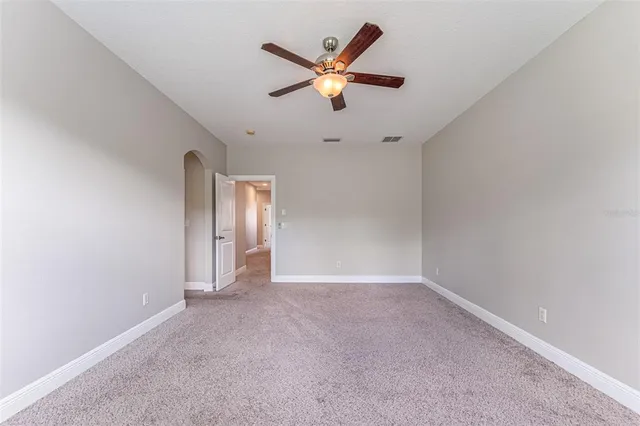 an empty room with a window and a fan